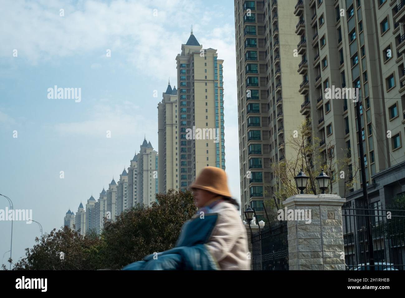 Una donna corre in bicicletta passando davanti alle proprietà residenziali Evergrande nel distretto di Wuqing, Tianjin, Cina. 19 ottobre 2021 Foto Stock