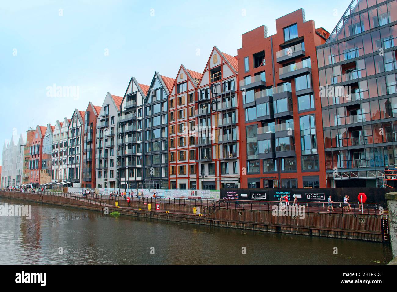 Bella architettura di edifici che si erge sopra il canale d'acqua in Danzica. Terrapieno a Danzica. Case moderne su un canale d'acqua in città. Tour Foto Stock