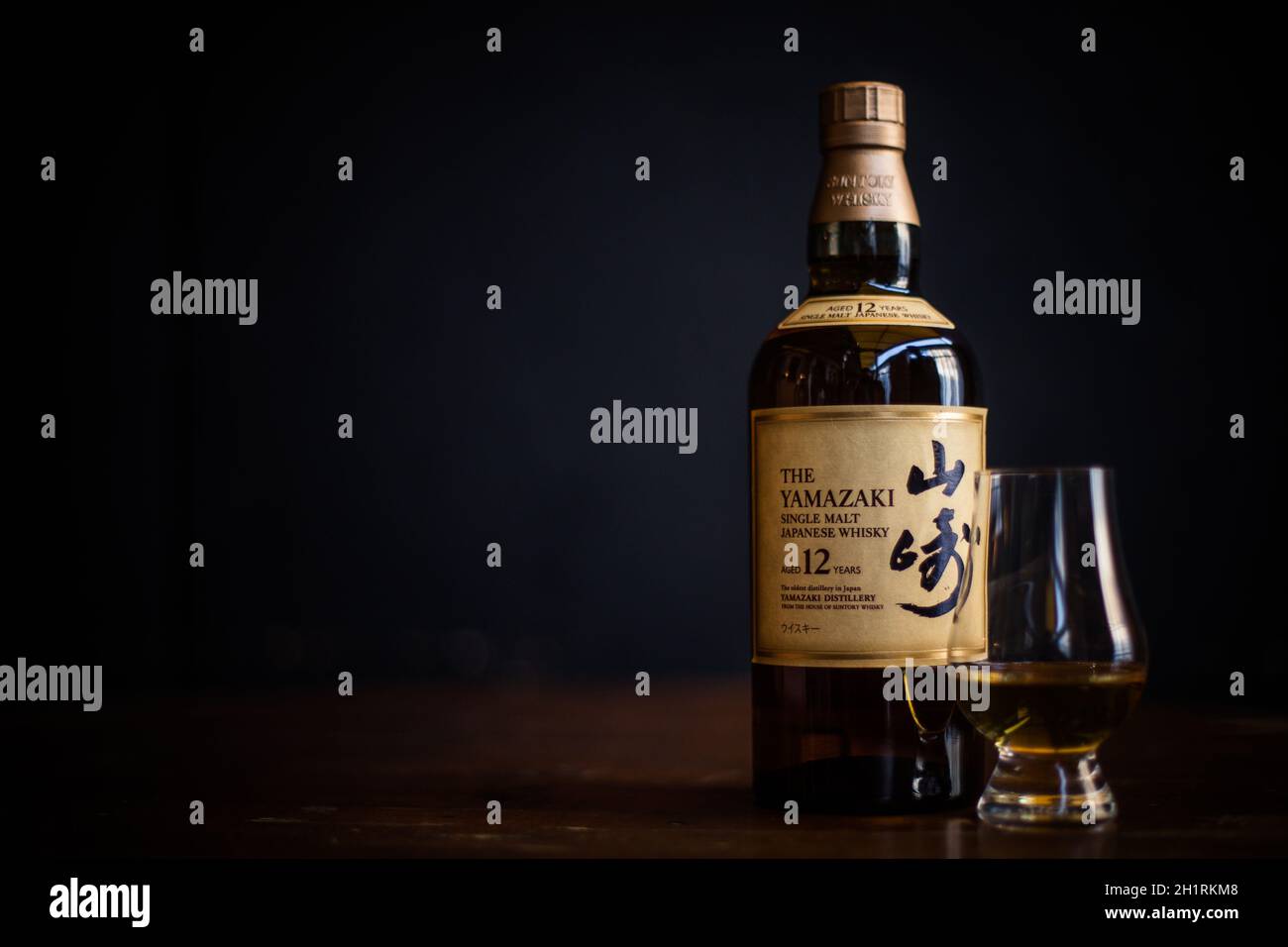 Bucarest, Romania - 25 febbraio 2021: Immagine editoriale illustrativa di una bottiglia di whisky giapponese al malto singolo Yamazaki e di un bicchiere di whisky Glencairn Foto Stock