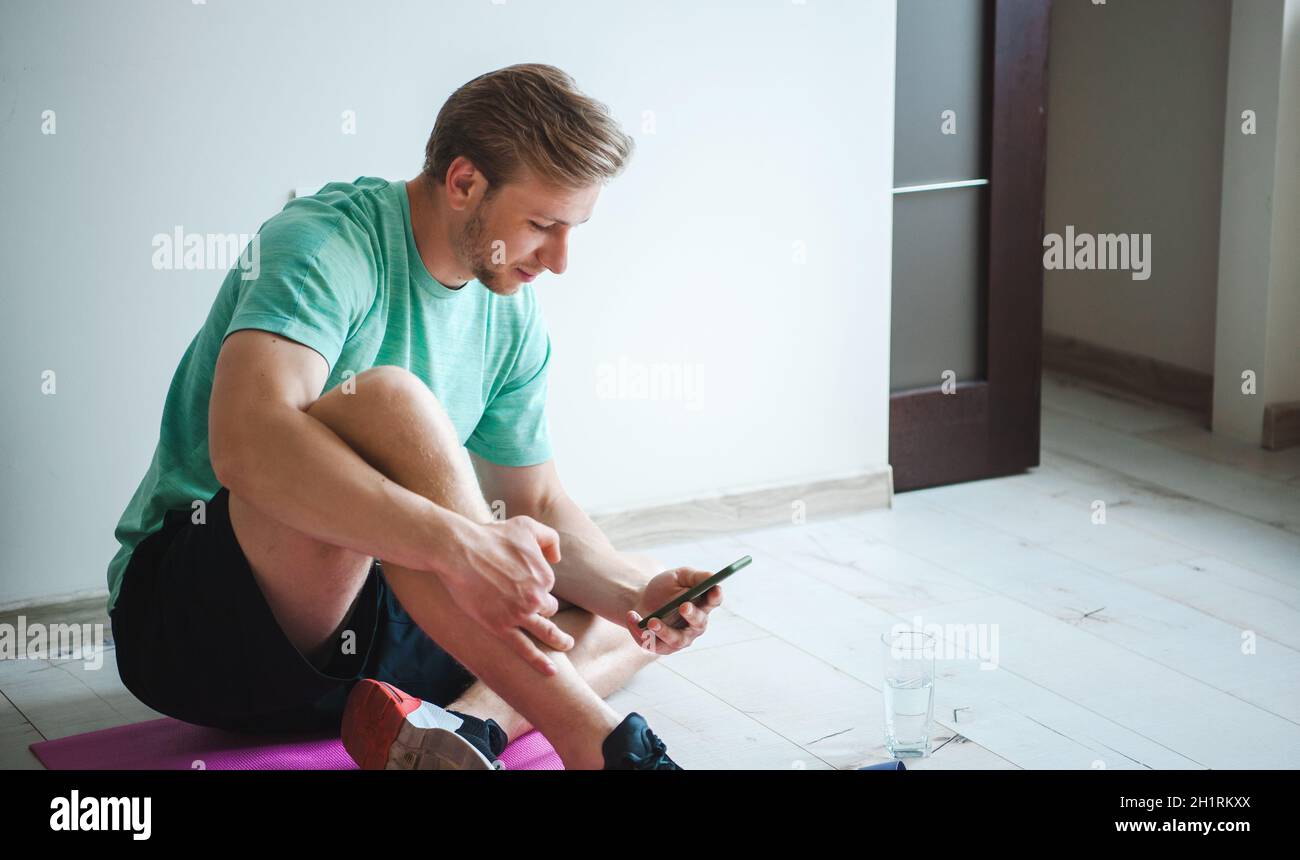 Stanchezza muscolare sudate uomo seduto con asciugamano sulla scatola in  croce palestra. Forte atleta maschio riposarsi dopo un duro allenamento  Foto stock - Alamy