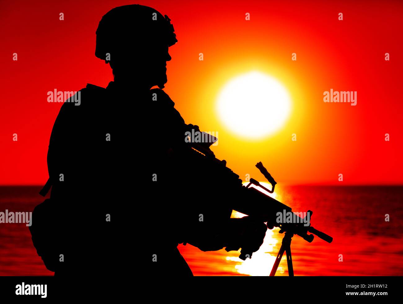 Silhouette di soldati fanteria dell'esercito, comando in casco da combattimento, mitragliatrice con armi leggere, in piedi sullo sfondo dell'orizzonte dell'oceano e del tramonto. Marine Co Foto Stock