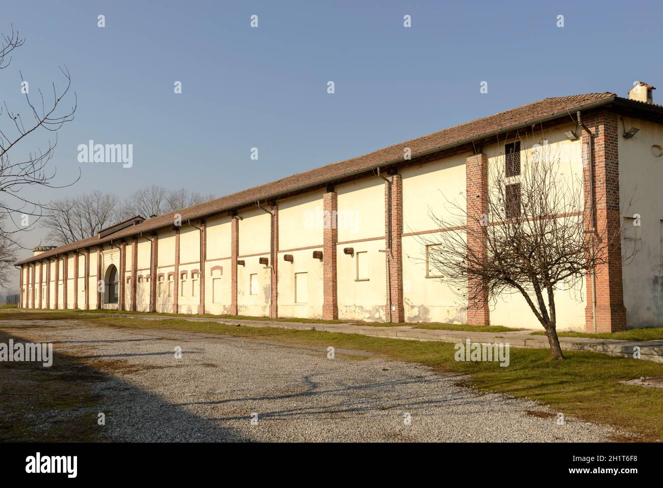 Vista esterna degli edifici rurali all'esterno dell'antica abbazia romanica di Mirasole, ripresa in luce invernale a Milano Foto Stock