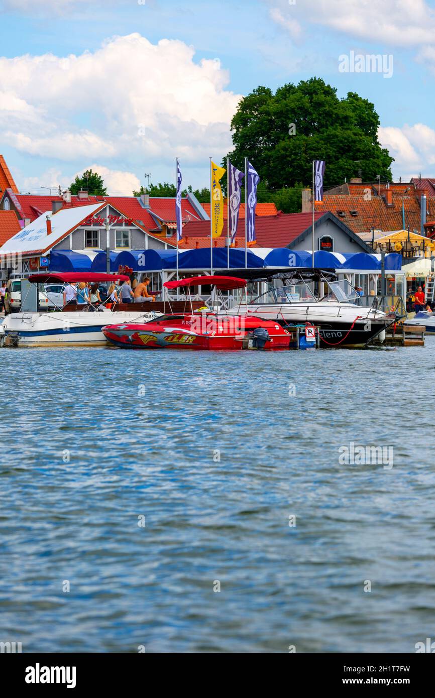 Mikolajki, Masuria, Polonia - 24 giugno 2020: Vista dal lago della città di Mikołajskie, porticciolo per yacht e barche sul lungomare. Mikolajki è chiamato Foto Stock