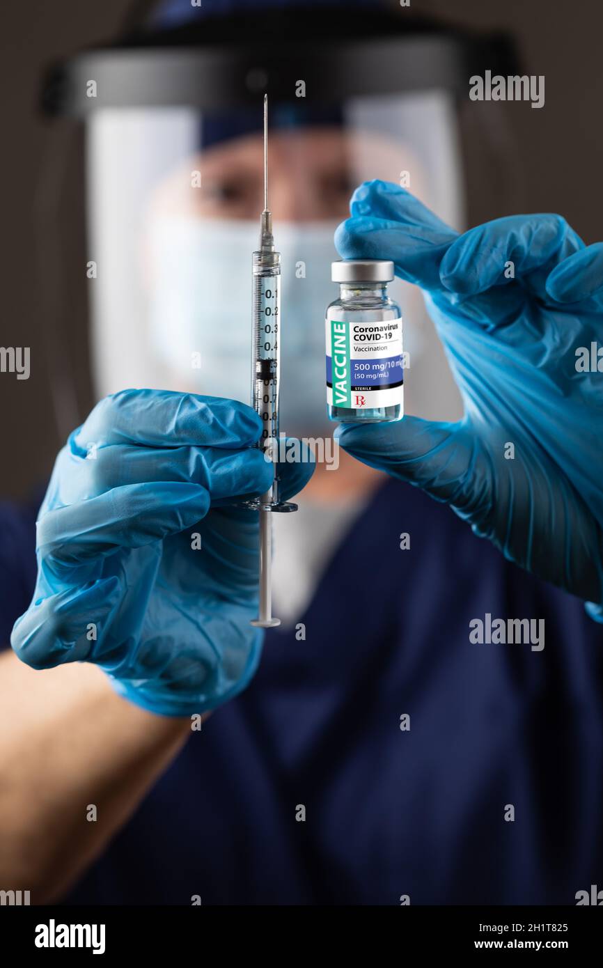 Medico o infermiere che indossa guanti chirurgici con flacone per vaccino e siringa medica. Foto Stock