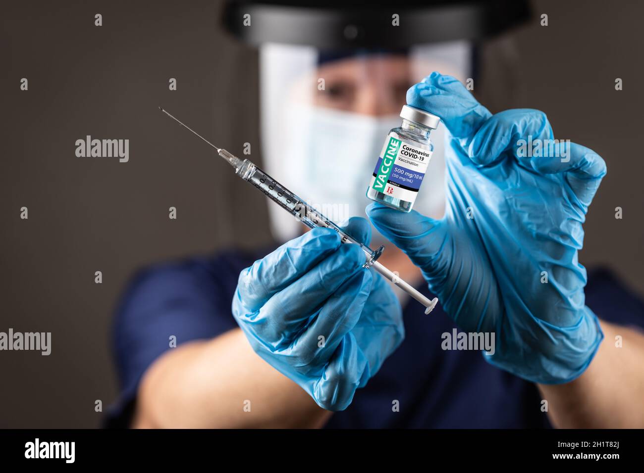 Medico o infermiere che indossa guanti chirurgici con flacone per vaccino e siringa medica. Foto Stock