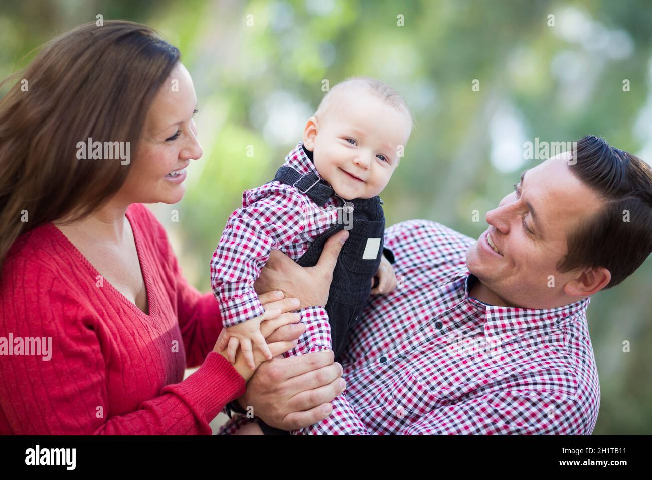 Adorabili poco Baby Boy divertendosi con la madre e il Padre all'esterno. Foto Stock