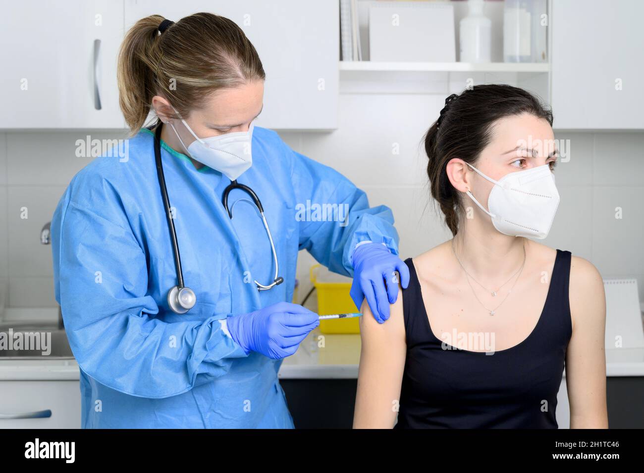Primo piano di giovane donna con maschera protettiva viso che si vaccina, concetto di coronavirus. Foto di alta qualità Foto Stock