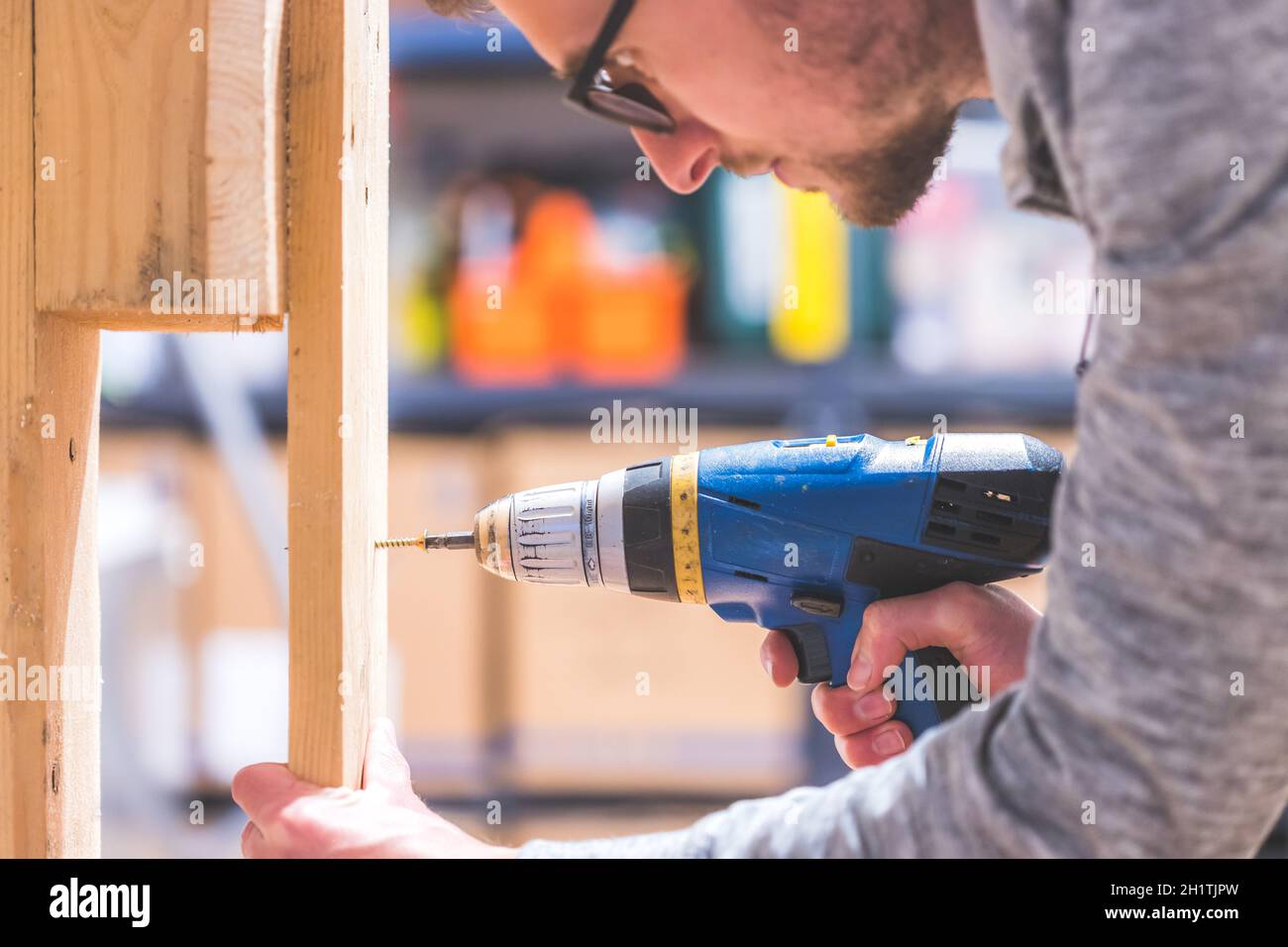 Fai da te l'handyman a casa sta usando un cacciavite cordless per l'avvitamento Foto Stock