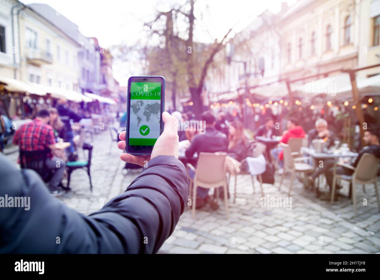 Vaccinato con certificato di immunizzazione su smartphone al ristorante o in terrazza. Foto Stock