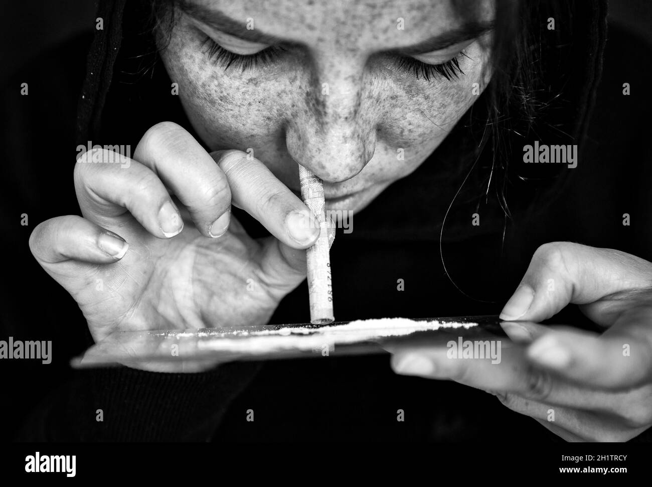 Drug Addict sniffing e russare Cocaine, velocità, Heroin o altro farmaco con soldi arrotolati su specchio con sfondo scuro, dipendenza, droghe, depressi c Foto Stock