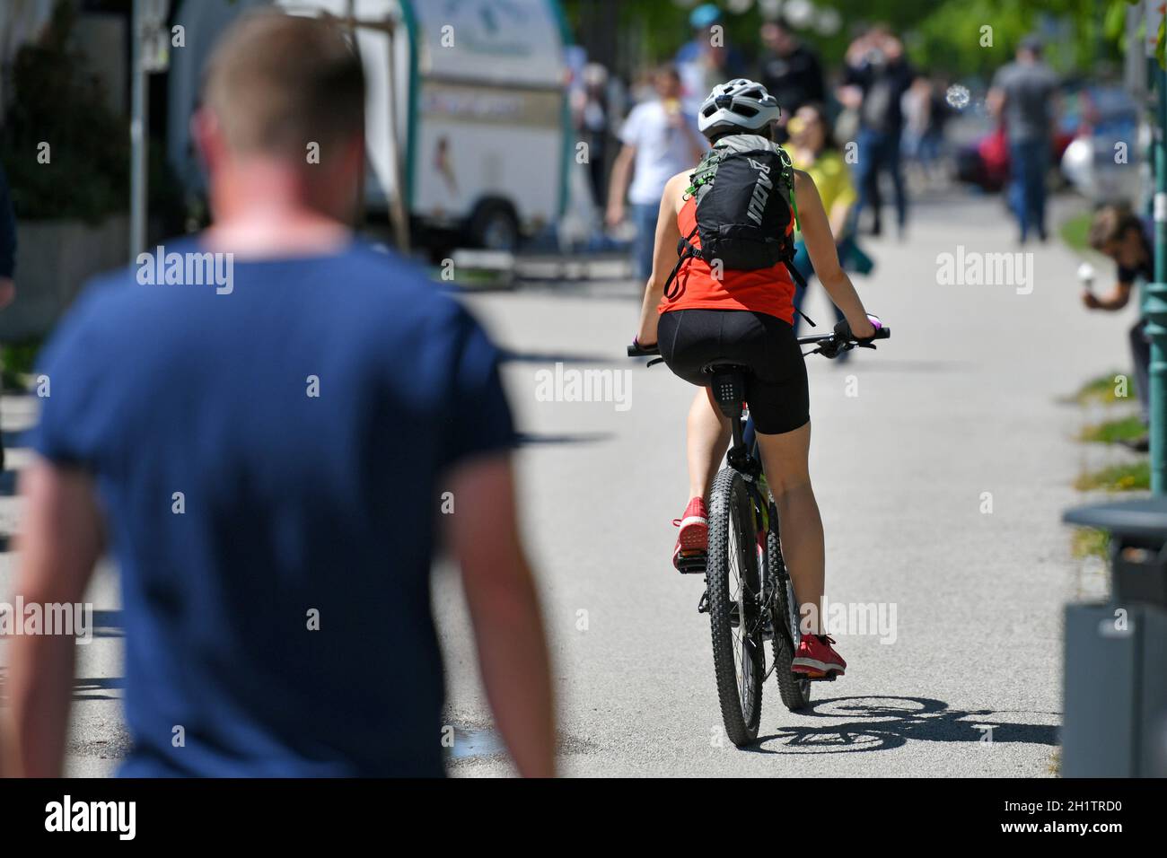 Eine junge Frau auf einem Fahrrad auf der Esplanade in Gmunden bei Sonnenschein, Österreich, Europa - una ragazza in bicicletta sull'Esplanade a Gmunden Foto Stock