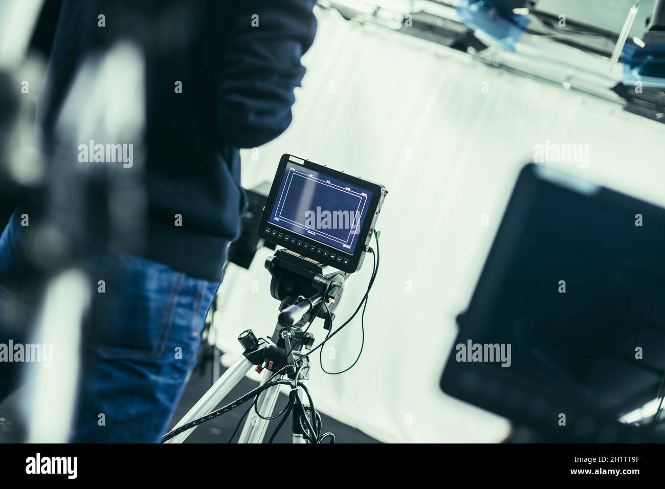 Il cameraman maschio è in funzione della fotocamera a pellicola in uno studio televisivo Foto Stock