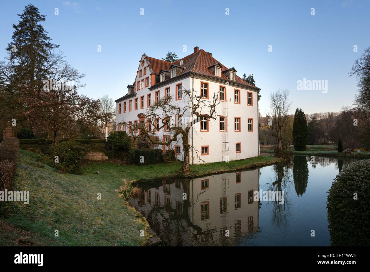 LINDLAR, GERMANIA - 15 APRILE 2021: Castello Georghausen vicino a Lindlar con riflessione d'acqua alle ore serali il 15 aprile 2021 a Bergisches Land, GE Foto Stock