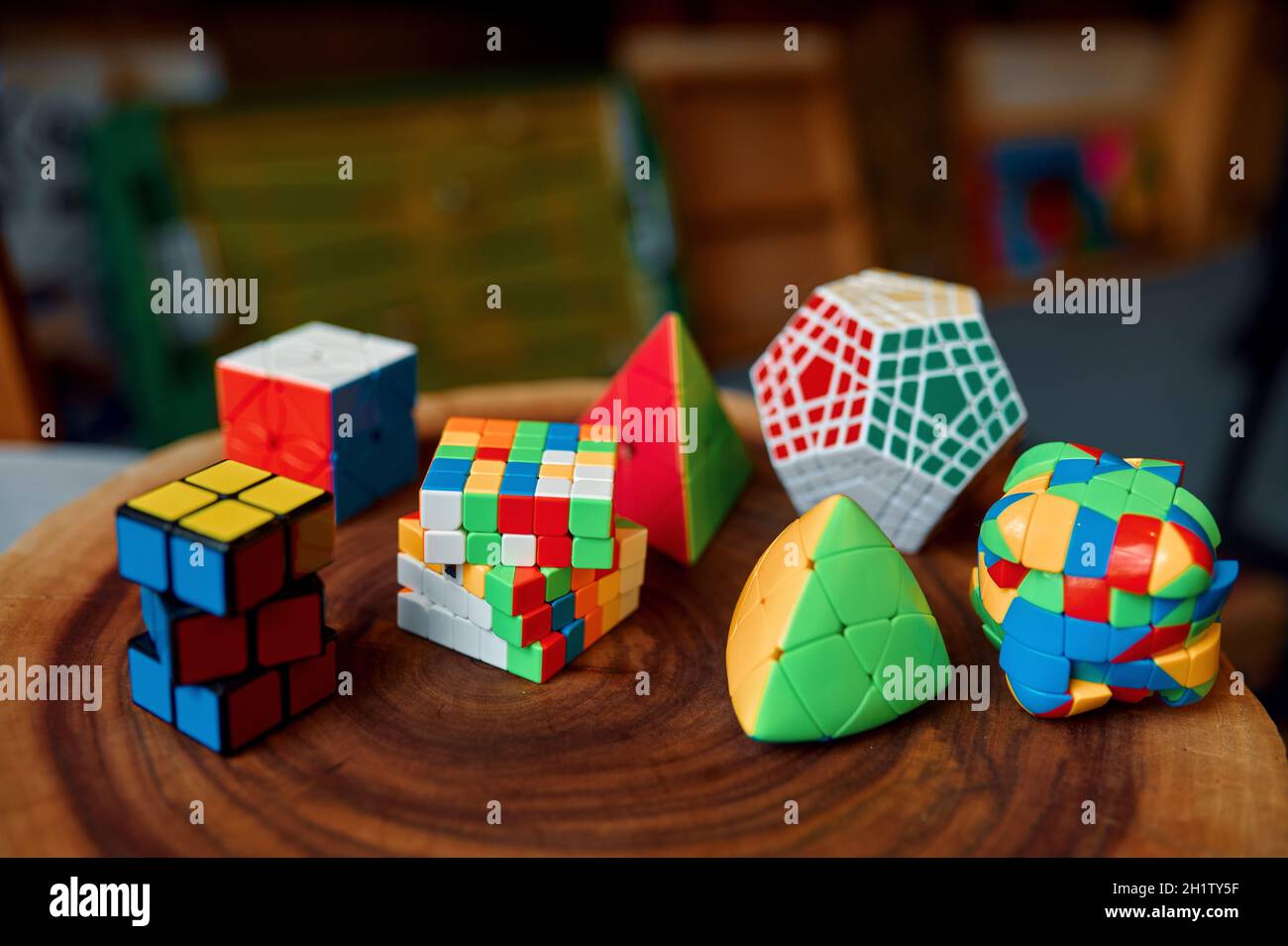 Diversi cubi puzzle colorati con forma inusuale su moncone in legno, vista closeup, nessuno. Giocattolo per l'allenamento mentale logico e cerebrale, gioco creativo, solv Foto Stock