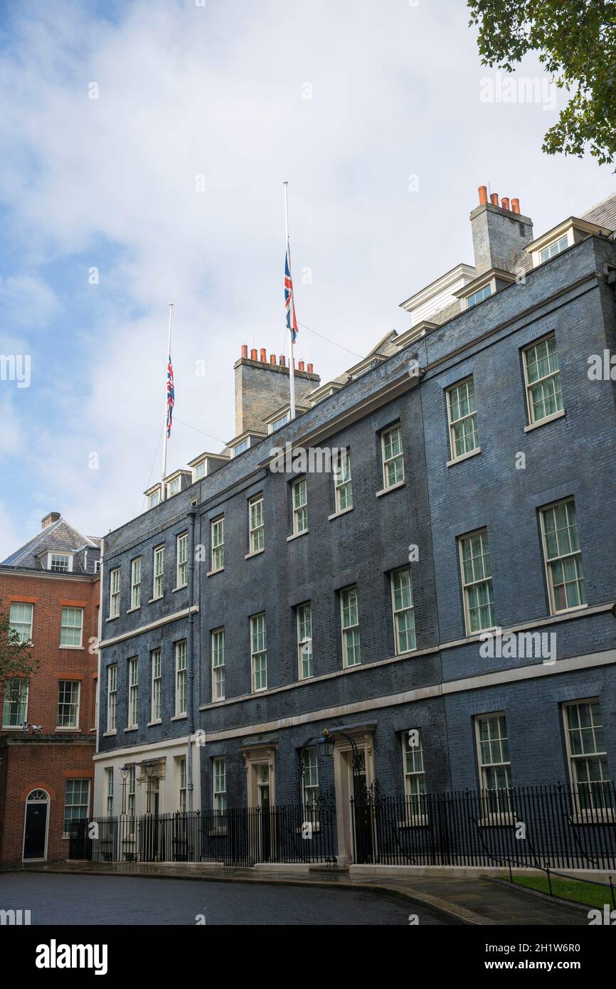 Union Flags vola a metà albero sulla cima dell’edificio che ospita 10 Downing Street, la residenza ufficiale del primo Ministro britannico. Foto Stock