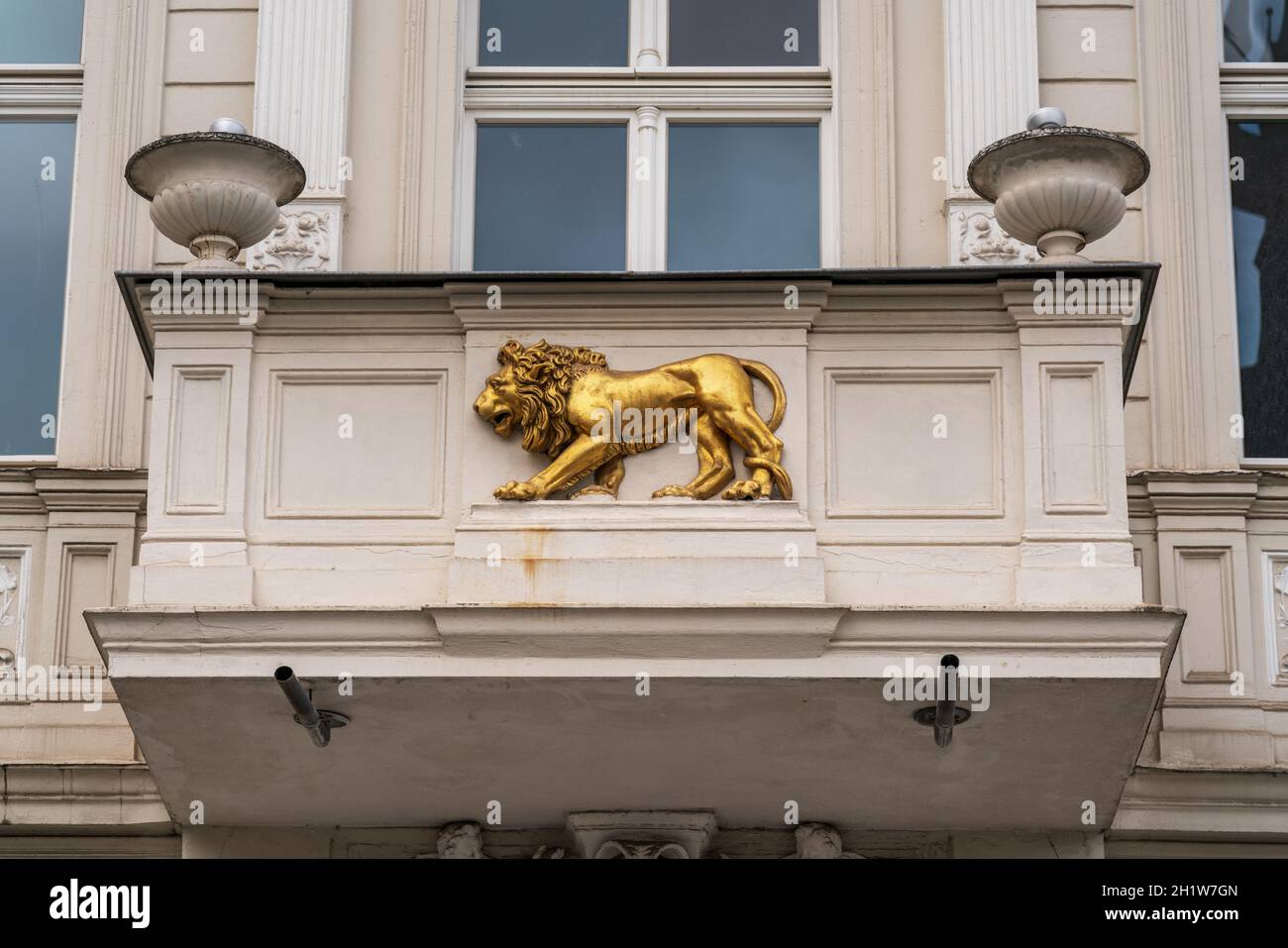 Un bassorilievo di un leone dorato sul balcone di un vecchio edificio. Foto Stock