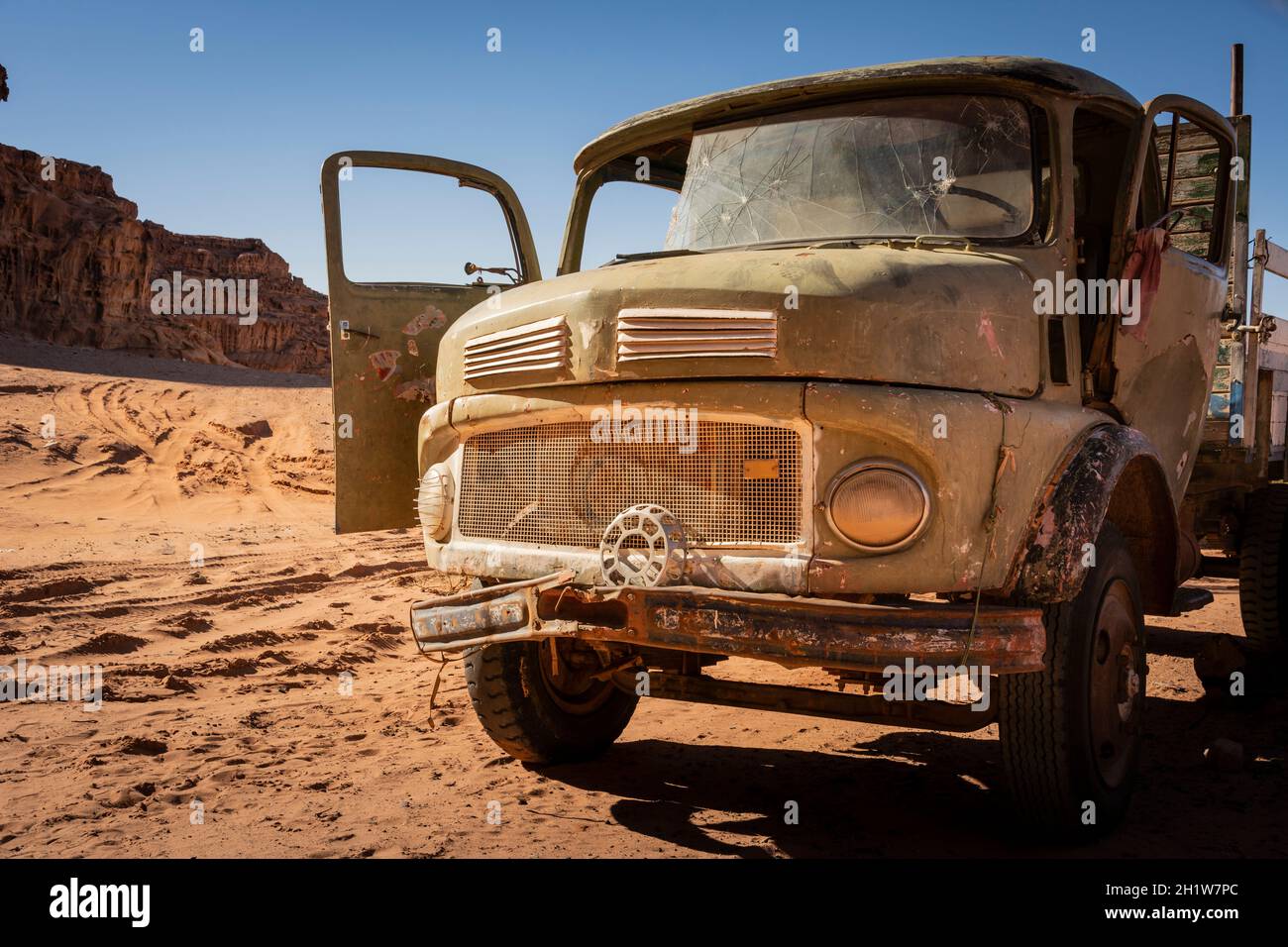 Wadi Rum, Giordania, 2020 marzo: Vecchio veicolo d'epoca arrugginito e usurato in piedi nel deserto. Fori a pallottola nel parabrezza. Veicolo abbandonato. Foto Stock