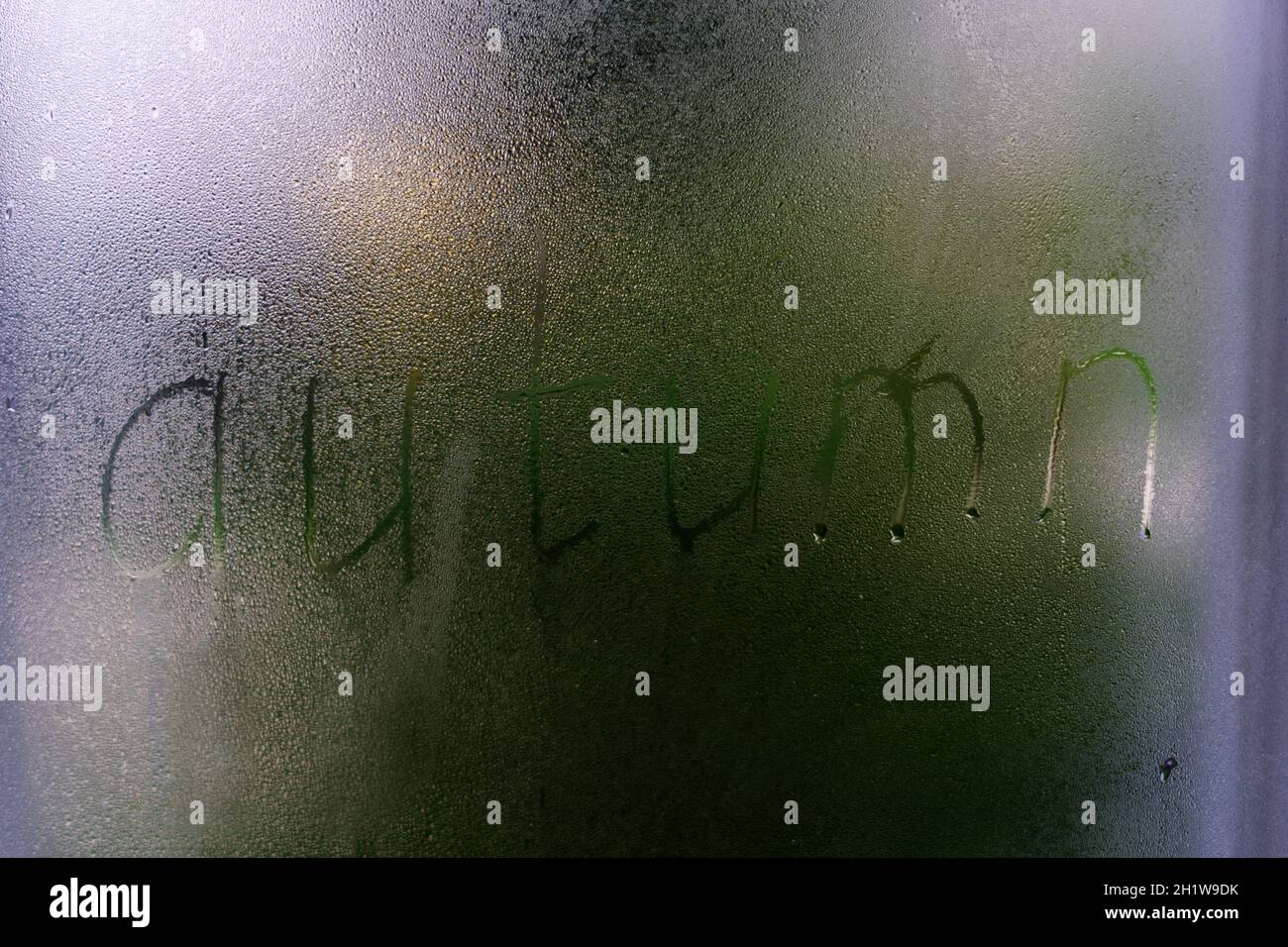 Vetro appannato su una finestra con scritta Finger Word Autumn. Foto concettuale con spazio per la copia Foto Stock