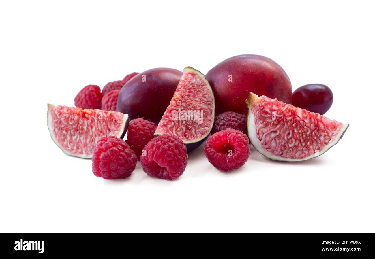 Bacche rosse e frutta isolate su sfondo bianco. Lamponi, fichi e prugne succulenti e deliziosi. Frutti di bosco misti con spazio di copia per il testo. Varie f Foto Stock