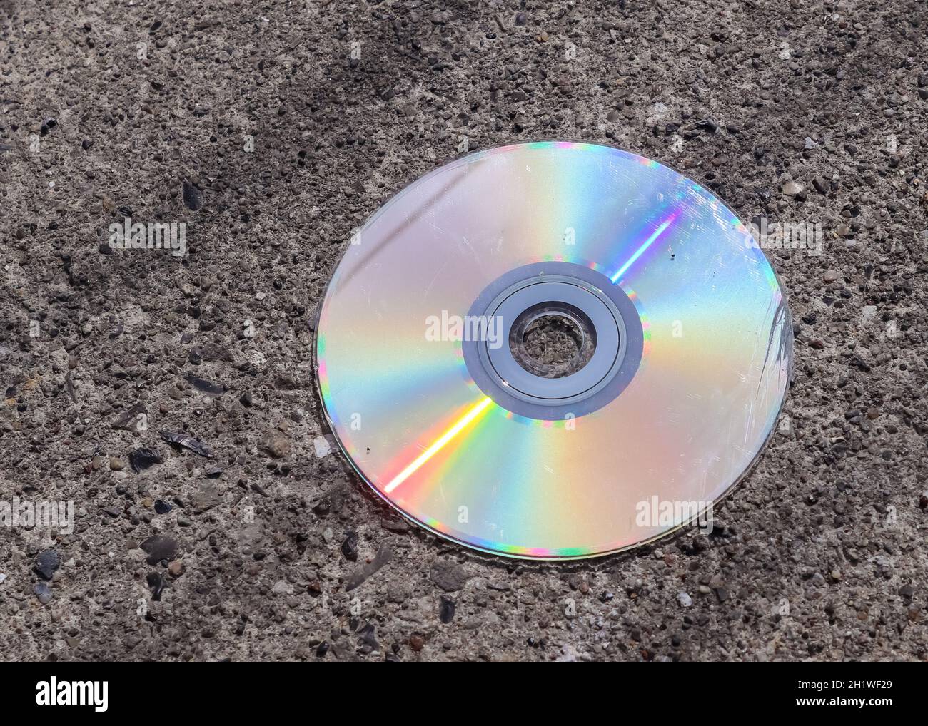 Vecchio compact disc usato su una strada asfaltata Foto Stock