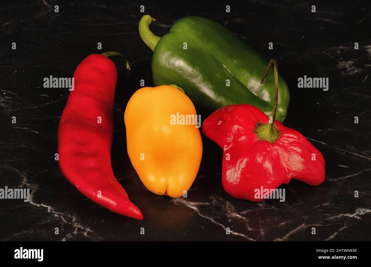 Ancora vita di campane verdi coltivate naturalmente, peperoni rossi e gialli. Foto Stock