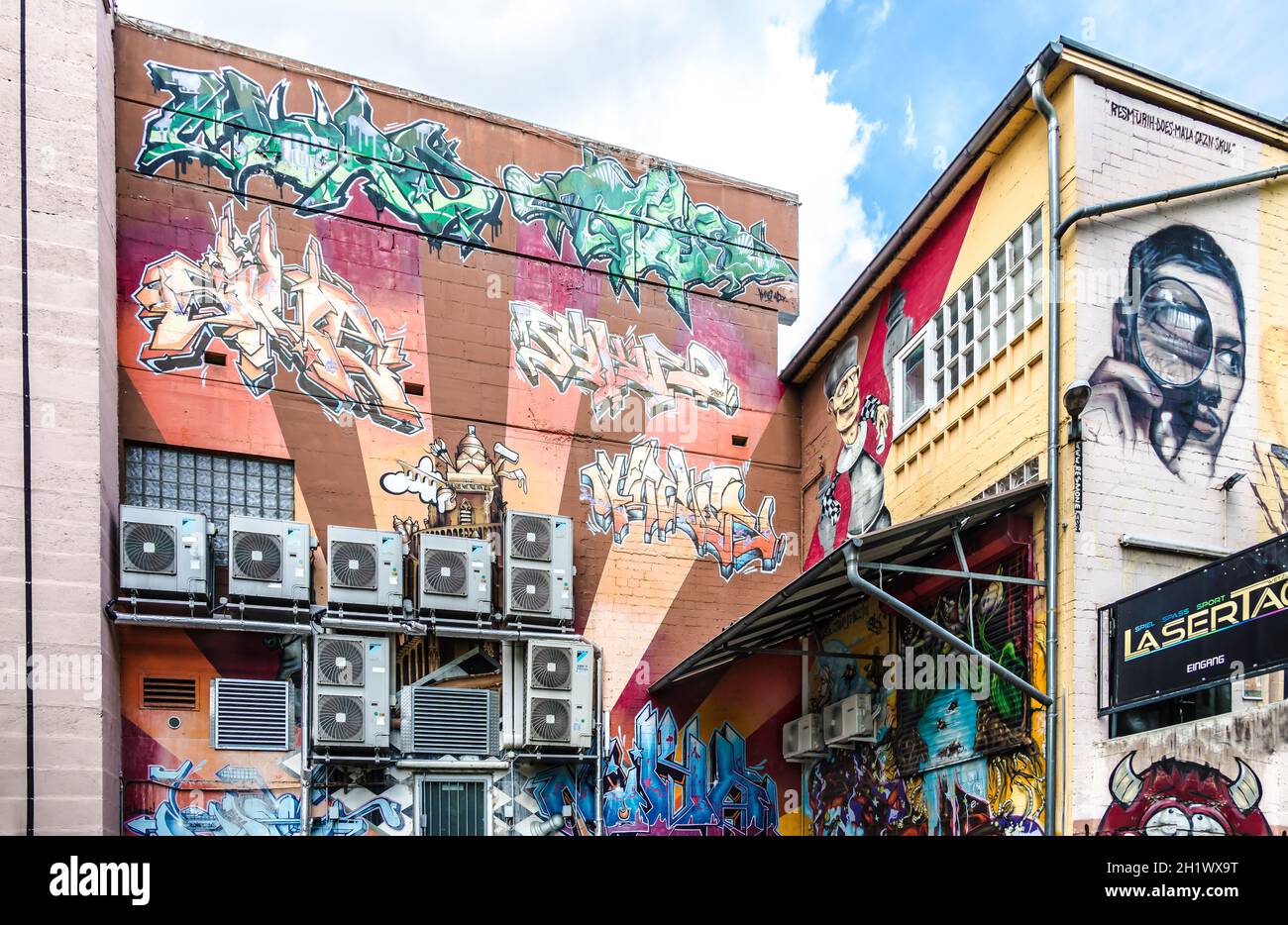 WETZLAR, GERMANIA - 23.05.2021: Aria condizionata montata su una facciata casa con graffiti colorati surround. Foto Stock