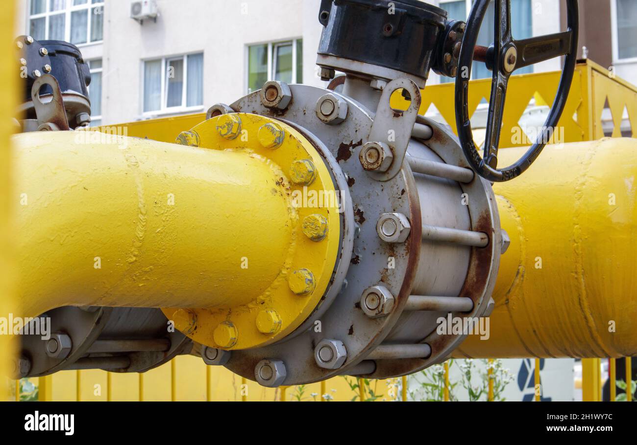 Tubo del gas giallo con rubinetto. Raccordi per oleodotti nell'industria del petrolio e del gas. Impianto di lavorazione del petrolio e del gas con raccordi per tubazioni. Sicurezza industriale Foto Stock