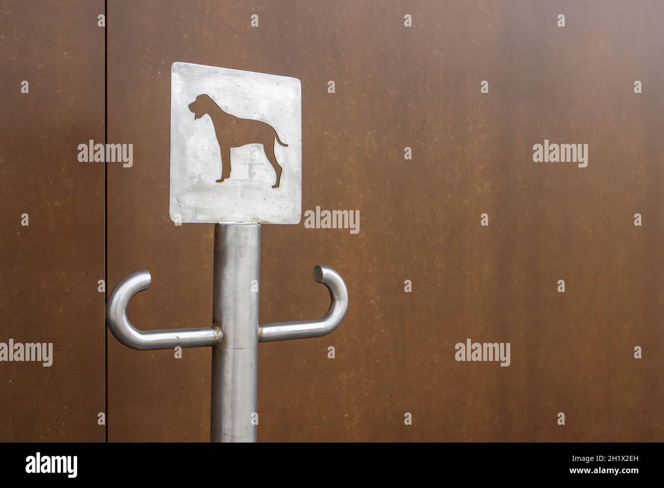 Primo piano di un cartello per il parcheggio all'aperto per cani. Un posto per un guinzaglio per i cani in attesa dei loro proprietari sulla strada. Fissare un guinzaglio, in luoghi pubblici o a t. Foto Stock