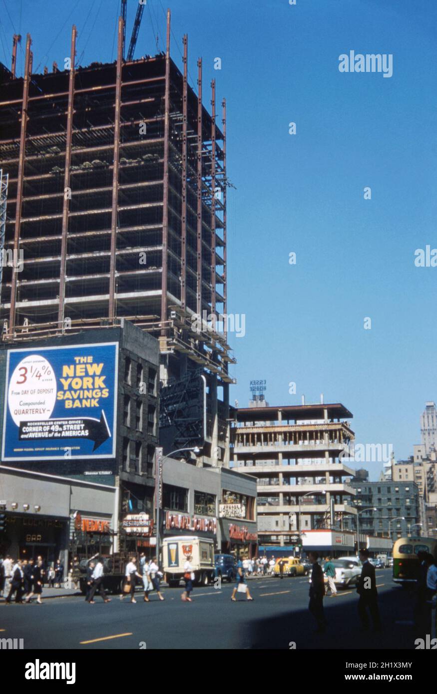Una vista che guarda verso nord a Manhattan lungo la 6th Avenue, vicino al suo incrocio con la W 49th Street, New York, USA alla fine degli anni '50. Questa strada è anche conosciuta come Avenue of the Americas (come sul gigantesco cartellone della New York Savings Bank in questa fotografia), anche se questo nome è raramente usato dai newyorkesi. È commerciale per gran parte della sua lunghezza con lo sviluppo del grattacielo evidente qui negli anni '50. Tuttavia, oggi questa sezione della 6th Avenue è ormai irriconoscibile – la zona è ormai quasi completamente cedita alla sede di aziende multinazionali – una fotografia d'epoca degli anni '50. Foto Stock