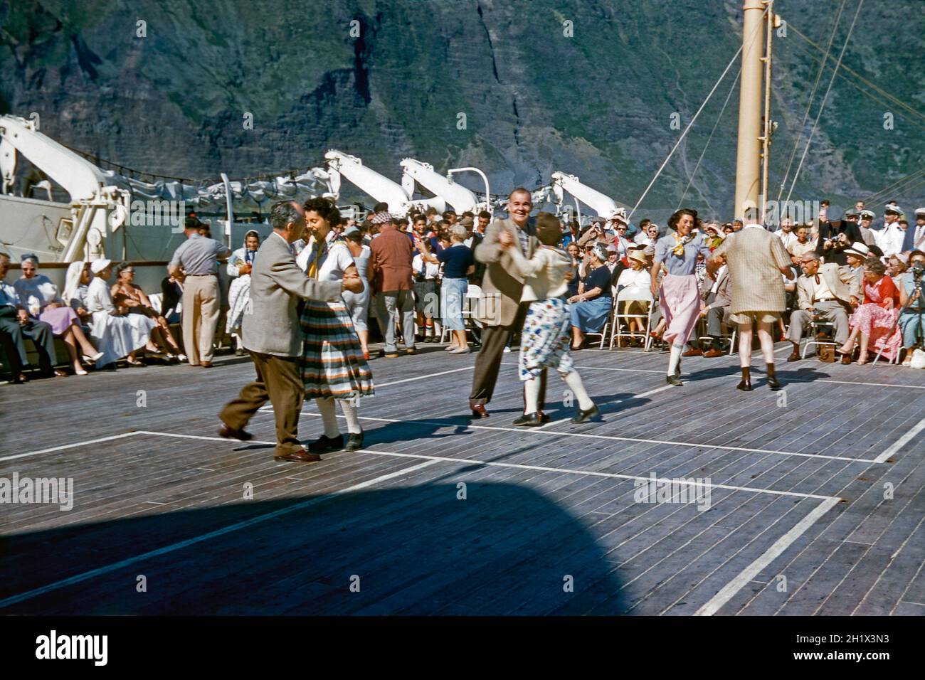 Balli sul ponte su una nave da crociera a metà degli anni '50. La nave era la linea oceanica, TSS Maasdam della Holland America Line (HAL). Sembra che un buon momento sia stato fatto da ballerini e spettatori. TSS Maasdam partì per il suo primo viaggio da Rotterdam a New York nel 1952. Anche se costruita con una disposizione di due classi, TSS Maasdam era una nave rivoluzionaria per il suo giorno, in quanto è stata essenzialmente costruita come un liner di classe turistica - una fotografia vintage degli anni '50. Foto Stock