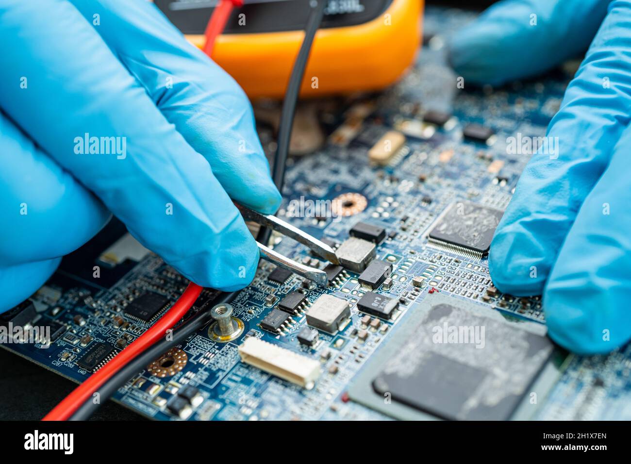 tecnico che ripara l'interno del disco rigido mediante saldatore. Circuito integrato: Il concetto di dati, hardware, tecnico e tecnologia. Foto Stock