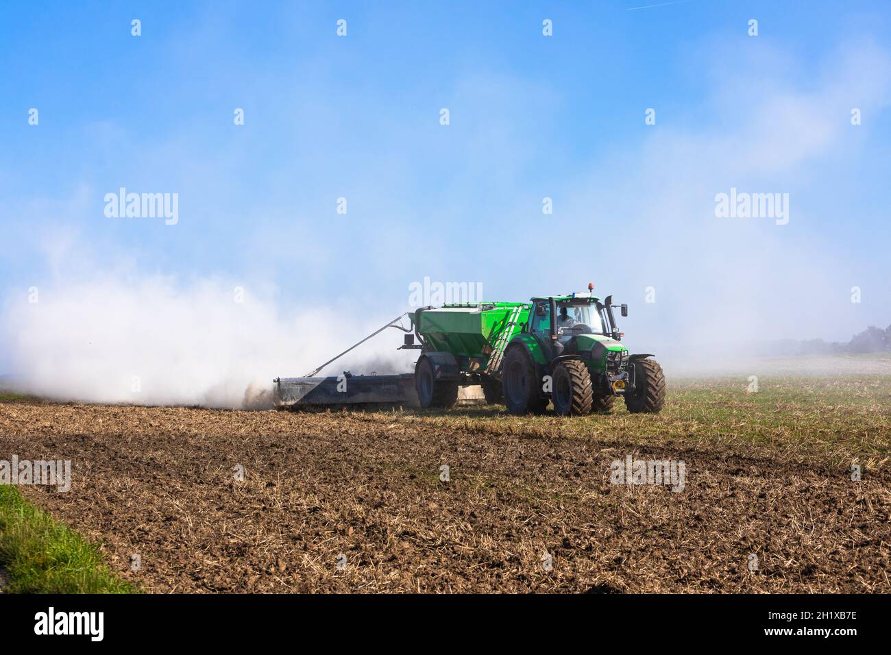 il trattore limando il terreno e produce molta polvere Foto Stock