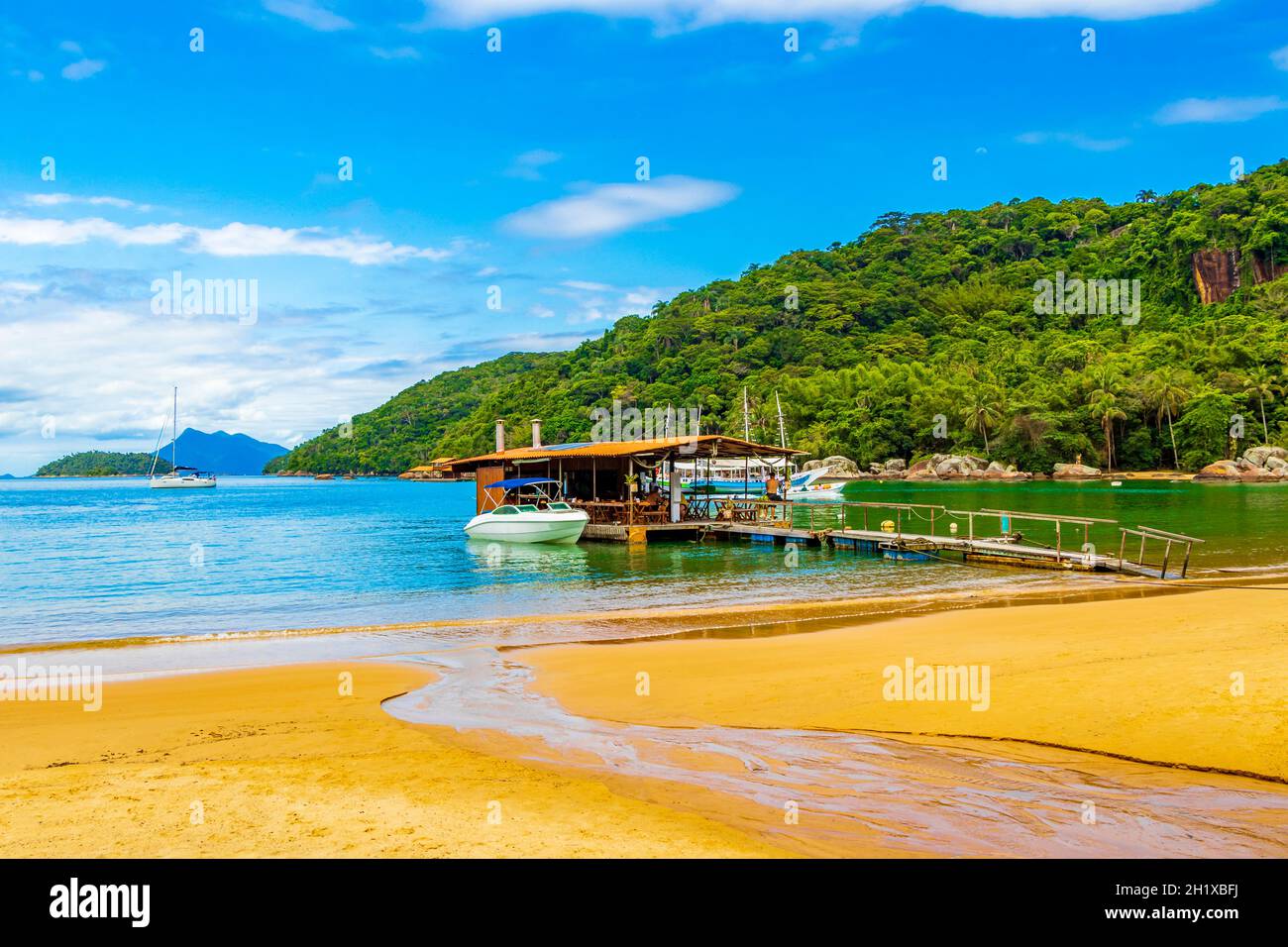 Incredibile spiaggia di Mangrove e Pouso spiaggia con ristorante nuoto e barche la grande isola tropicale Ilha Grande Rio de Janeiro Brasile. Foto Stock