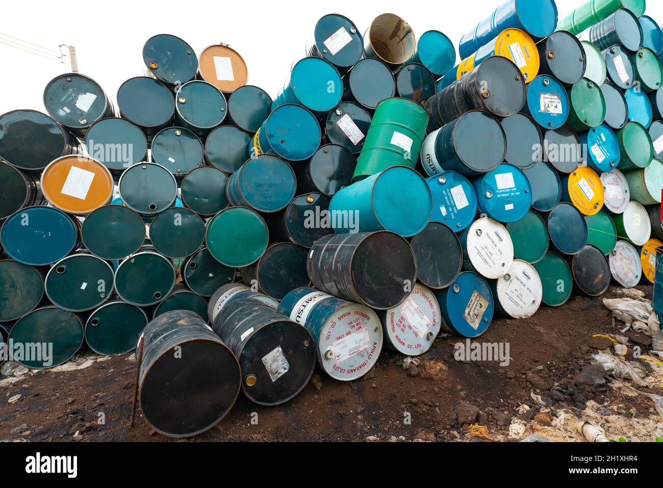 CHACHOENGSAO, THAILANDIA-24 GIUGNO 2021 : vecchie botti chimiche impilate. Serbatoio di plastificante in acciaio con etichetta. Prodotti chimici blu, verde, nero e giallo ba Foto Stock