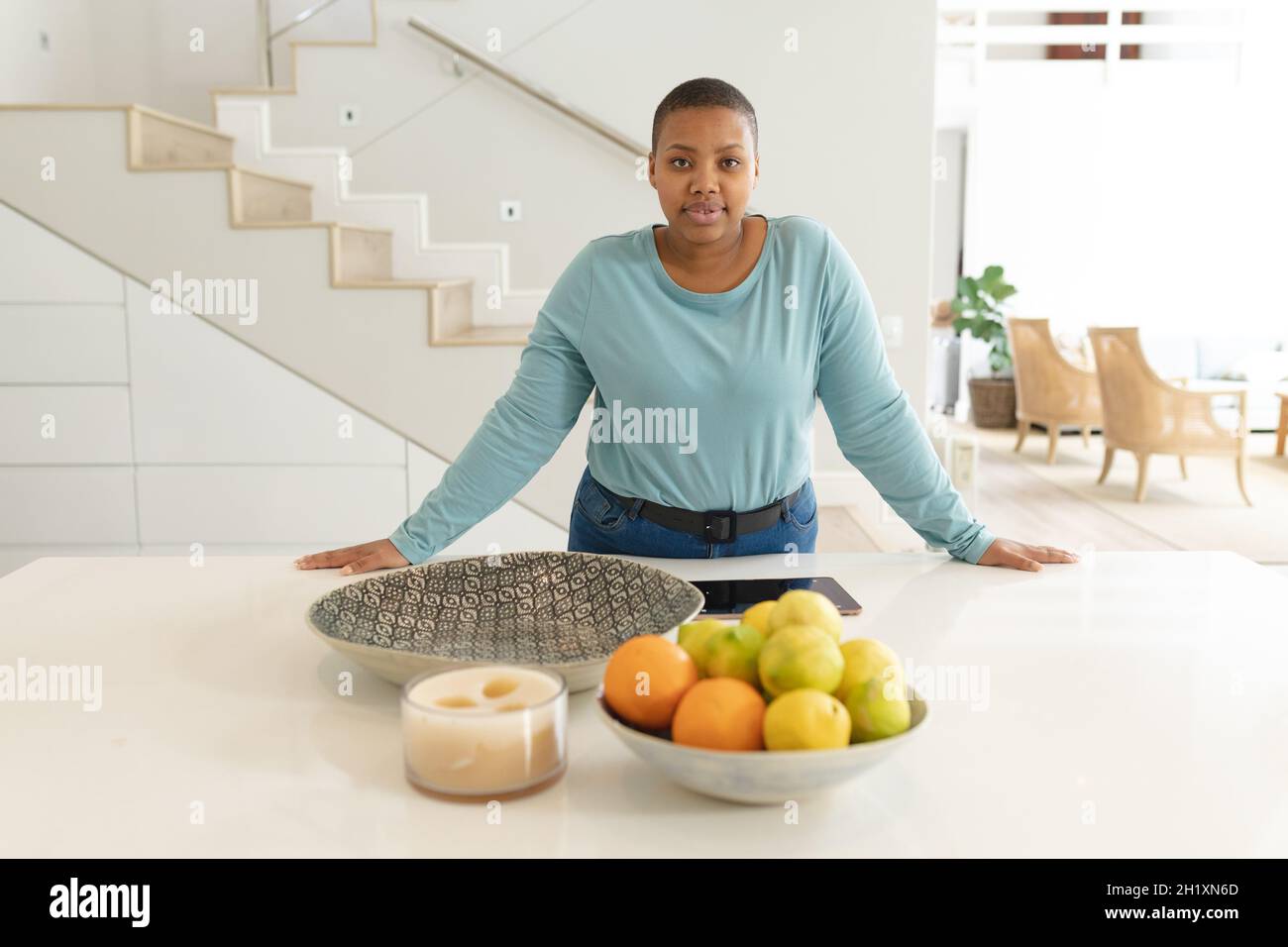 African american Plus taglia donna in piedi in cucina Foto Stock