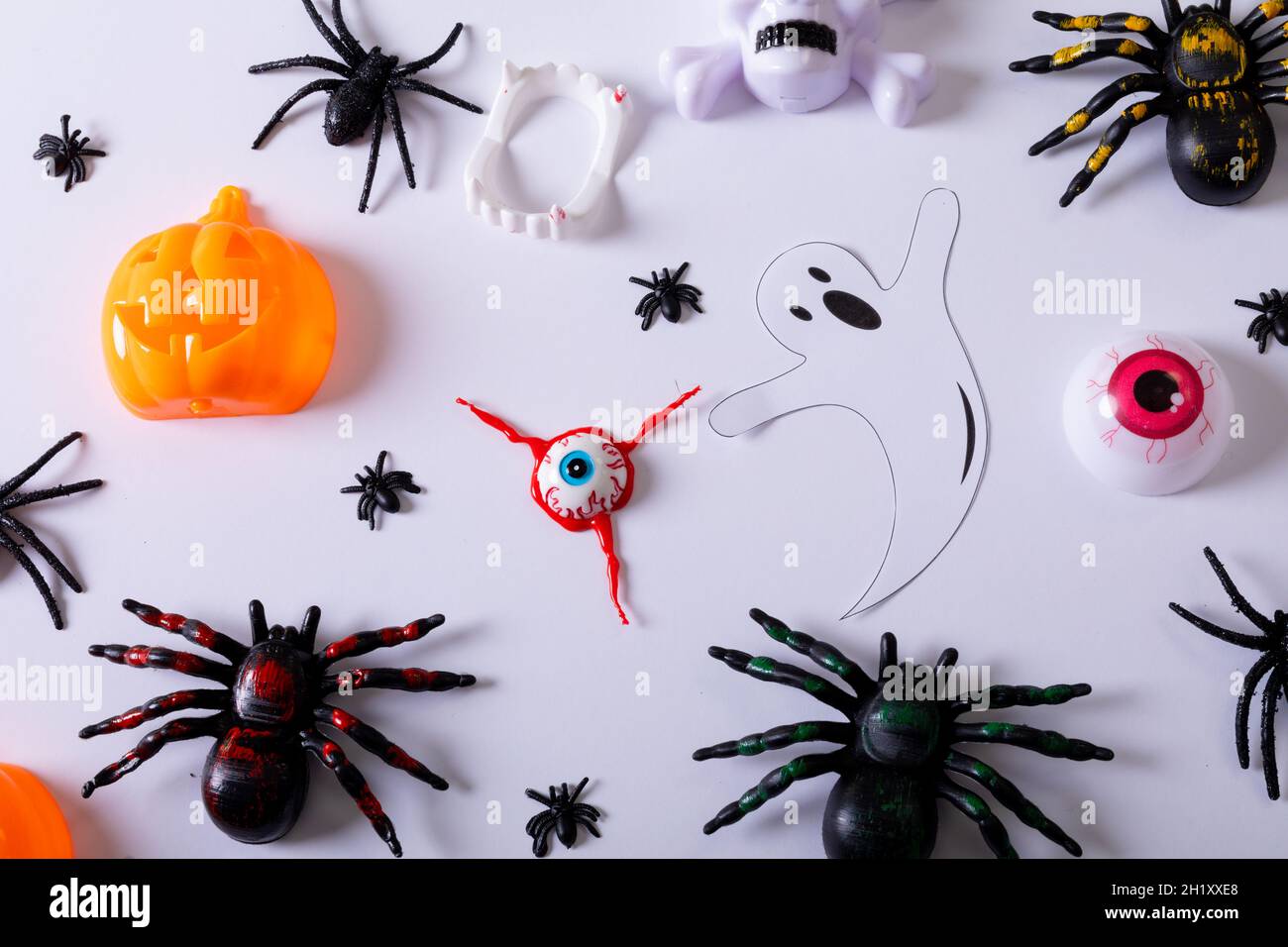 Composizione di decorazioni di Halloween con ragni, fantasma e zucca su sfondo bianco Foto Stock