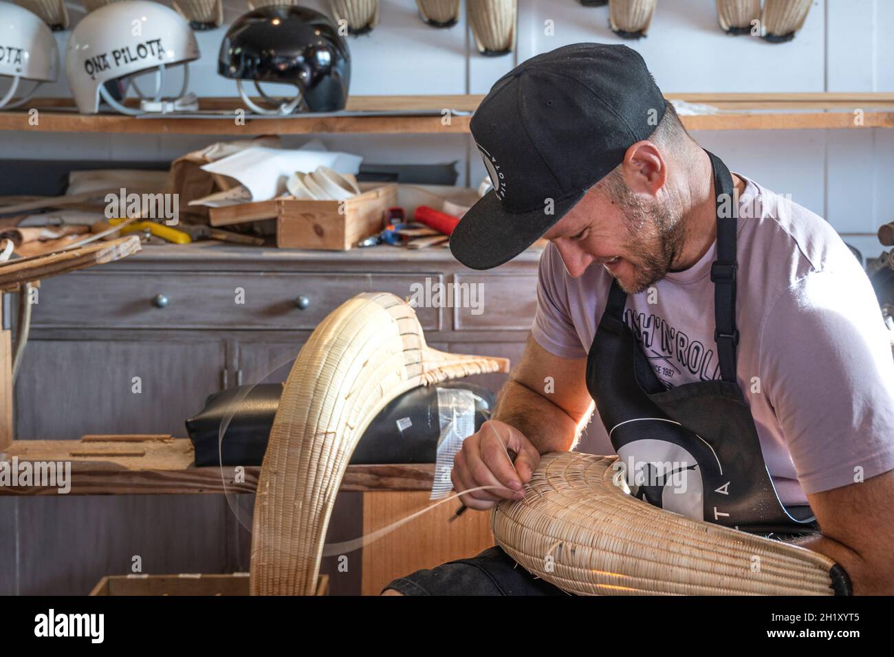 L'ex campione del mondo Patxi Tambourindeguy ripara un grande chistera nel suo laboratorio di pelota a Bidart, Francia Foto Stock