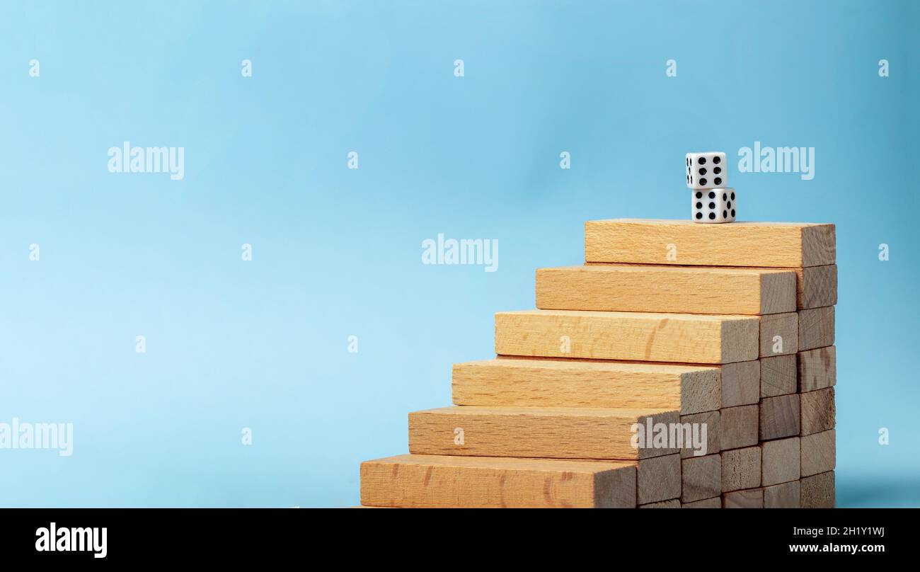 Primo piano la foto delle scale in blocchi di legno e un paio di dices simboleggia il ruolo della fortuna ın successo. Foto Stock