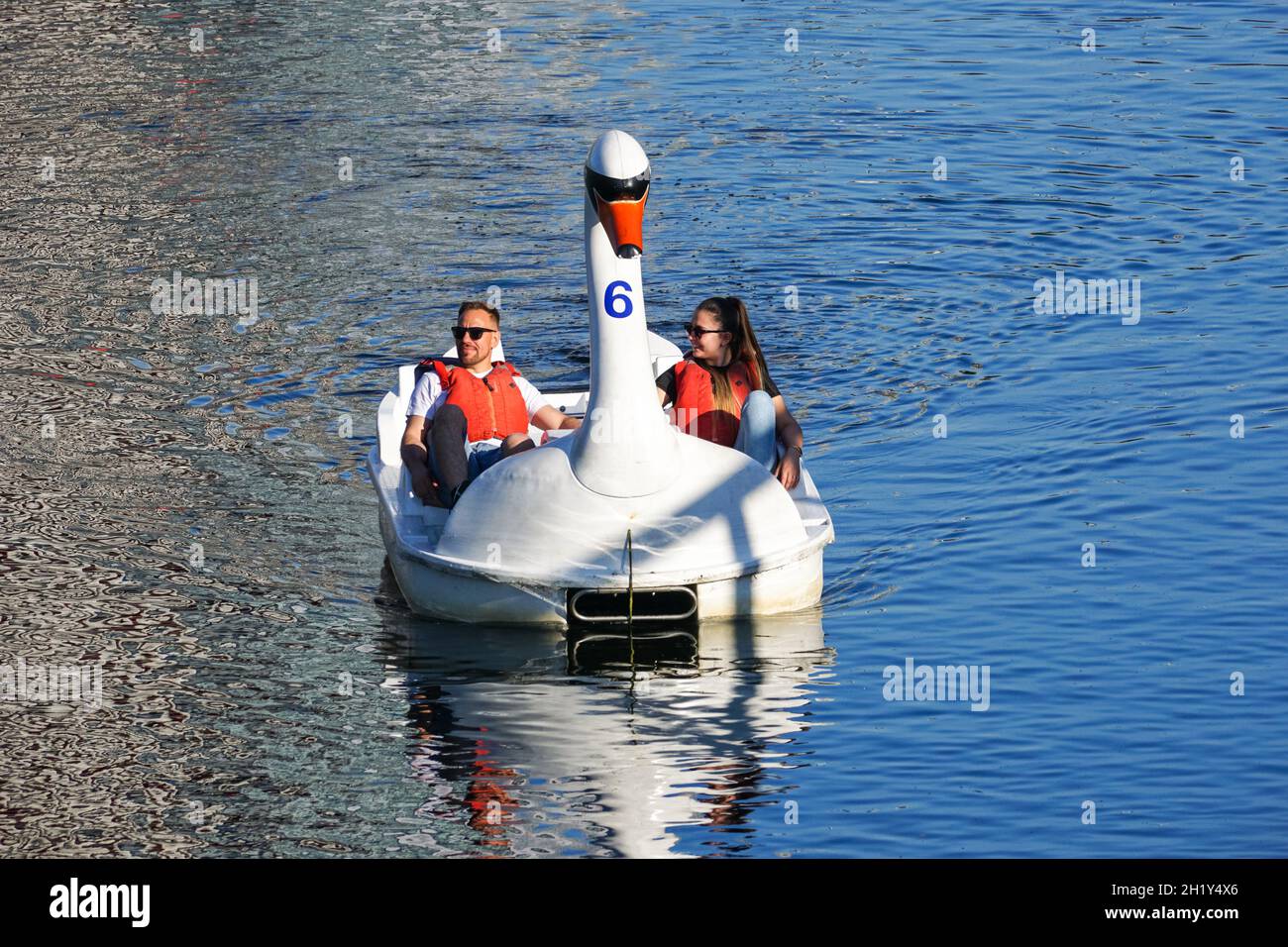La gente gode di una giornata di sole in cigno pedalos sul fiume Lea al Queen Elizabeth Olympic Park, Londra Inghilterra Regno Unito Foto Stock La gente gode di una giornata di sole in cigno pedalos sul fiume Lea al Queen Elizabeth Olympic Park, Londra Inghilterra Regno Unito Foto Stock