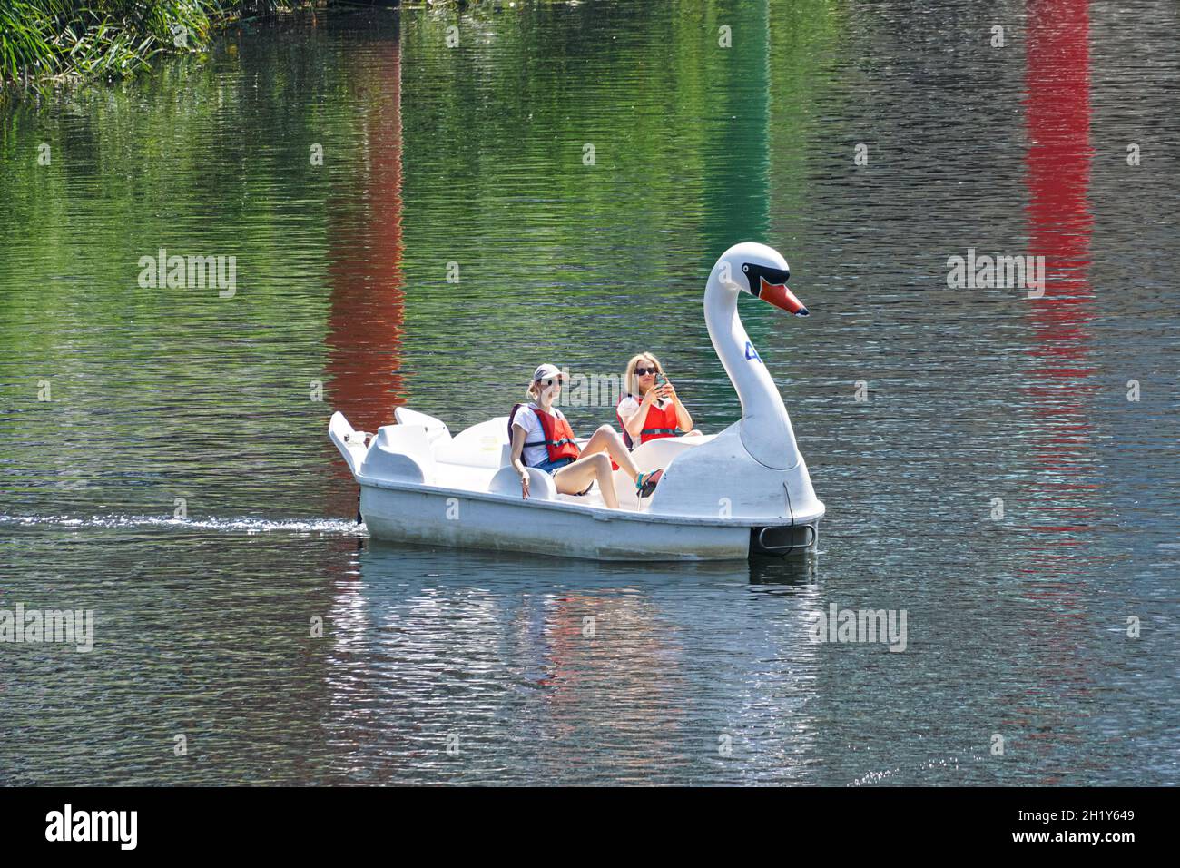 La gente gode di una giornata di sole in cigno pedalos sul fiume Lea al Queen Elizabeth Olympic Park, Londra Inghilterra Regno Unito Foto Stock La gente gode di una giornata di sole in cigno pedalos sul fiume Lea al Queen Elizabeth Olympic Park, Londra Inghilterra Regno Unito Foto Stock