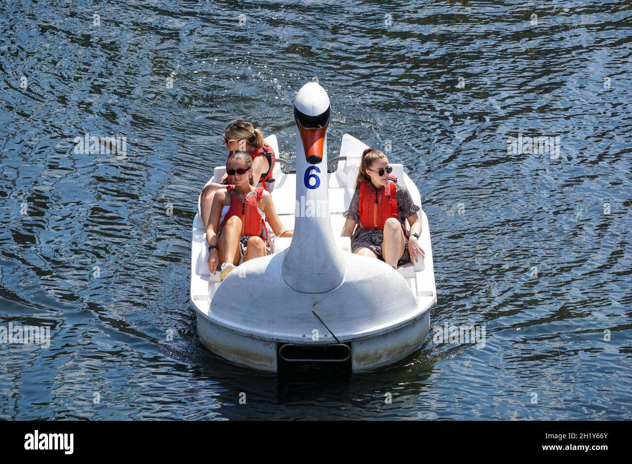 La gente gode di una giornata di sole in cigno pedalos sul fiume Lea al Queen Elizabeth Olympic Park, Londra Inghilterra Regno Unito Foto Stock La gente gode di una giornata di sole in cigno pedalos sul fiume Lea al Queen Elizabeth Olympic Park, Londra Inghilterra Regno Unito Foto Stock