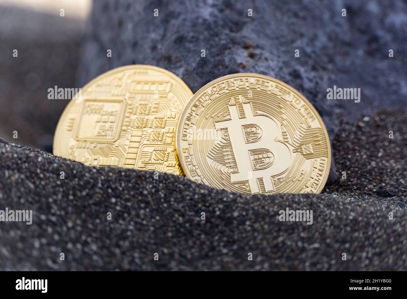 Due monete della moneta digitale Bitcoin nella sabbia Foto Stock