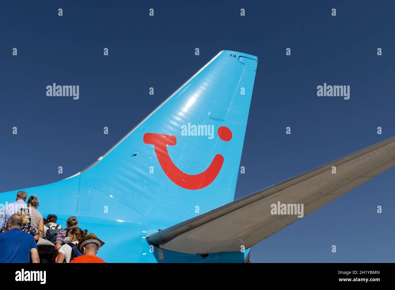 Coda di un aeroplano con il logo di TUIfly con passeggeri che si imbarcano attraverso la porta posteriore - Tenerife South Airport, 06.10.21 Foto Stock