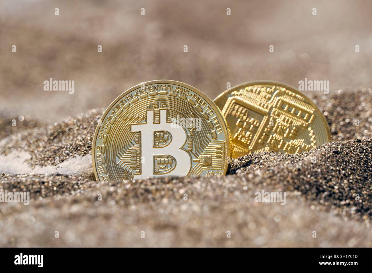 Due monete della moneta digitale Bitcoin nella sabbia Foto Stock