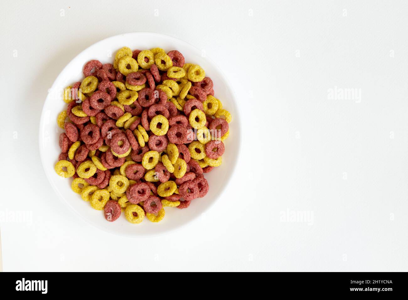 ciotola di cereali interi anelli isolati su sfondo bianco, sano concetto di colazione, piatto di anelli deliziosi con spazio vuoto per il testo, vista dall'alto Foto Stock