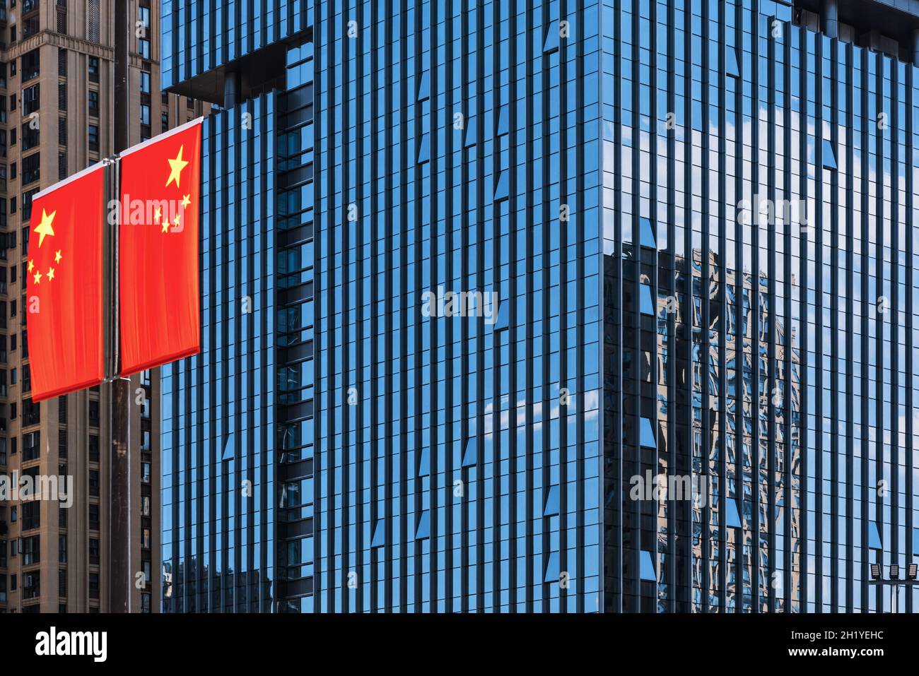 Bandiera cinese contro i moderni grattacieli di vetro con cielo blu riflettente a Chengdu, provincia del Sichuan, Cina Foto Stock