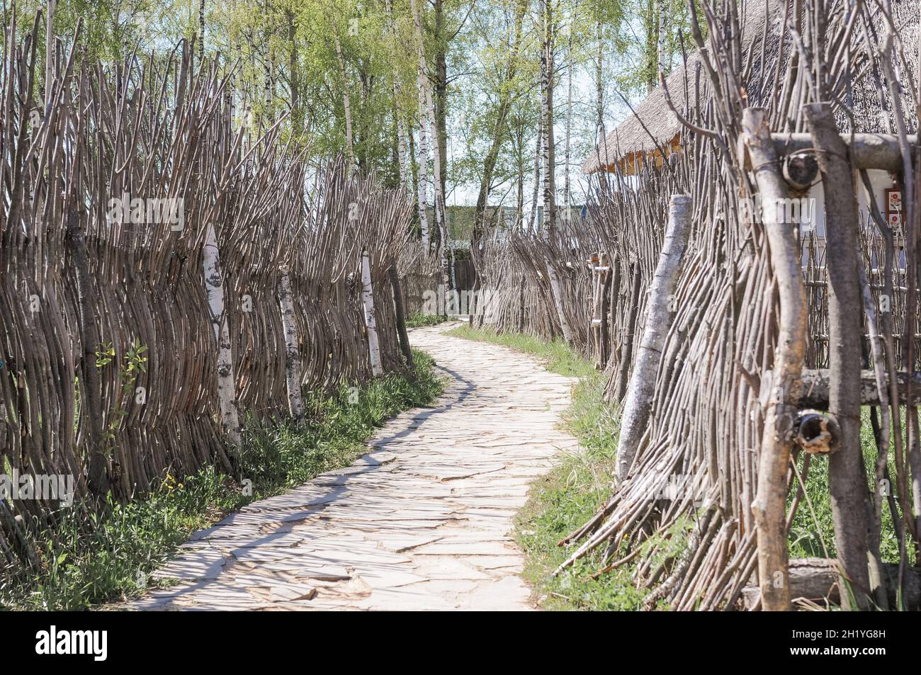 un sentiero rustico lastricato di pietra e una recinzione in legno di natura naturale materiali di rami di albero. cura per l'ecologia della natura e plastica libera Foto Stock