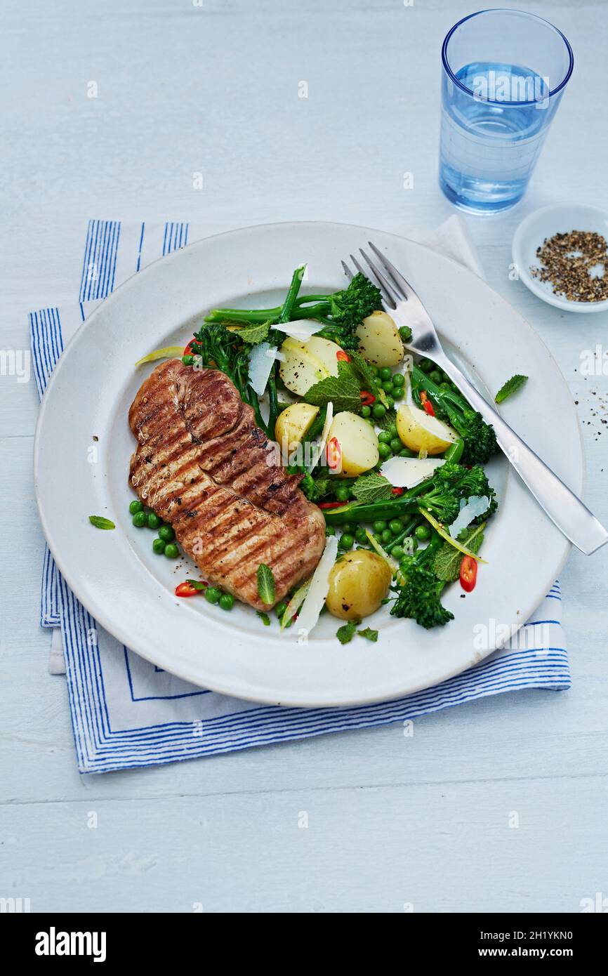 Fette di maiale con insalata di verdure calde Foto Stock