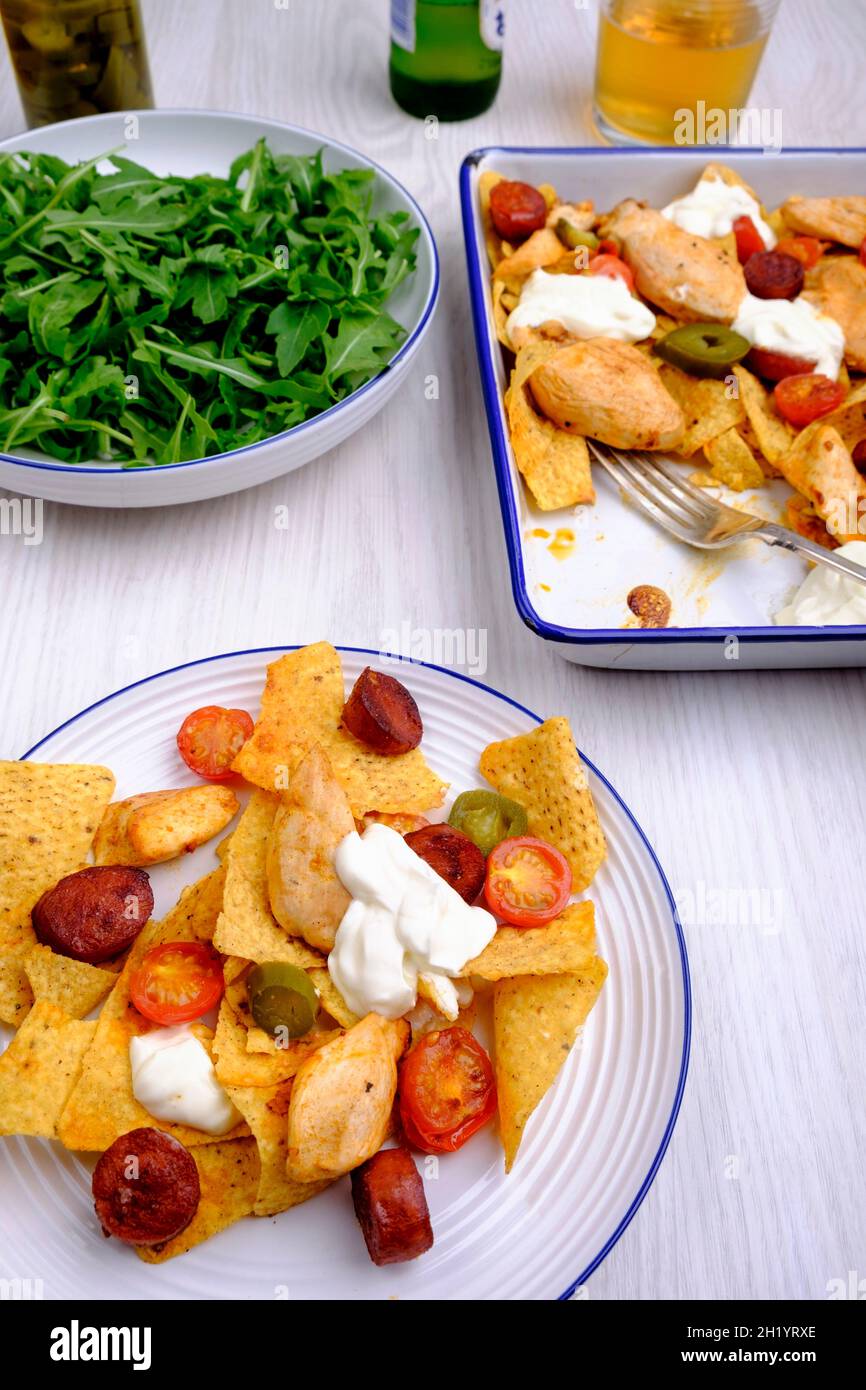 Nachos a una pentola con pollo, chorizo, peperoni jalapeno e pomodori ciliegini Foto Stock