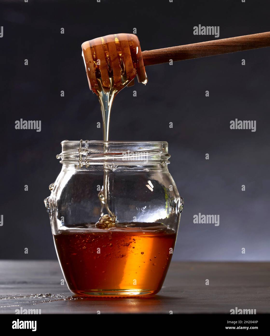 Il miele il gocciolamento da un bilanciere di miele Foto Stock